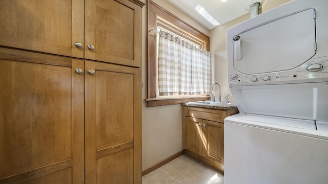 611 S Hennepin Ave, Dixon, IL 61021 - washroom featuring estacked washer and dryer, cabinet space, and light tile patterned floors