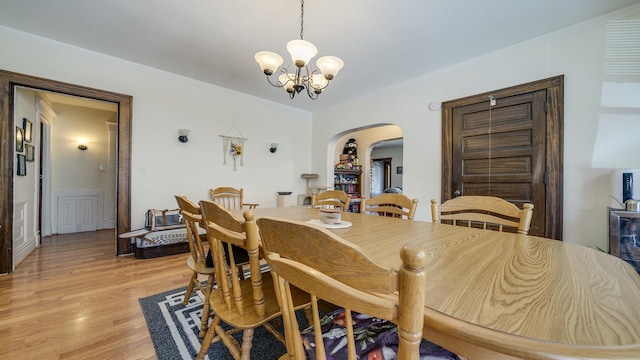 611 S Hennepin Ave, Dixon, IL 61021 - dining area with arched walkways, a chandelier, light wood-style floors, and crown molding