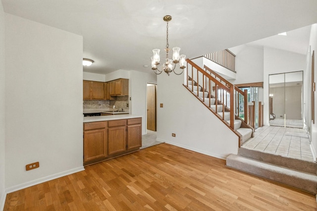 2S772 Timber Dr, Warrenville, IL 60555 - kitchen with brown cabinets, a chandelier, light wood finished floors, tasteful backsplash, and light countertops