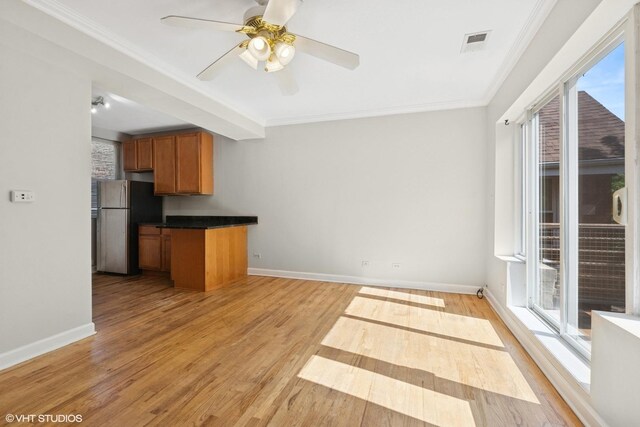 4610 N Monticello Ave Unit 3E, Chicago, IL 60625 - kitchen with freestanding refrigerator, brown cabinetry, dark countertops, crown molding, and light wood-style flooring