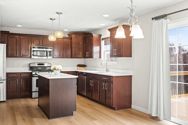 1312 Wicklow Dr, Bloomington, IL 61705 - kitchen featuring stainless steel appliances, light countertops, light wood-type flooring, a center island, and pendant lighting
