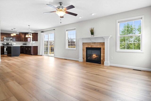 1312 Wicklow Dr, Bloomington, IL 61705 - unfurnished living room with a fireplace, a ceiling fan, light wood finished floors, a chandelier, and recessed lighting