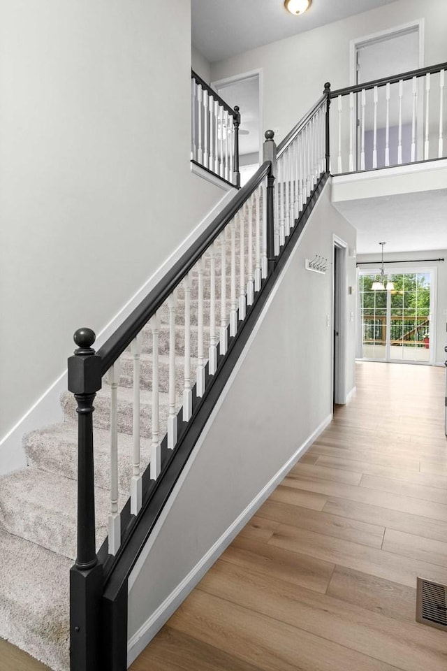 1312 Wicklow Dr, Bloomington, IL 61705 - stairway with wood finished floors, a chandelier, and a towering ceiling