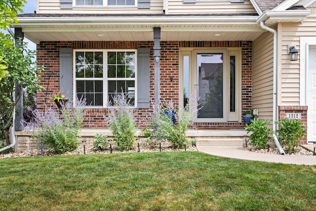 1312 Wicklow Dr, Bloomington, IL 61705 - view of exterior entry featuring covered porch, brick siding, and a yard