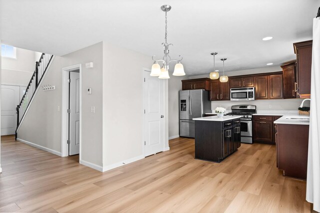 1312 Wicklow Dr, Bloomington, IL 61705 - kitchen featuring stainless steel appliances, a kitchen island, light countertops, light wood-type flooring, and dark brown cabinets