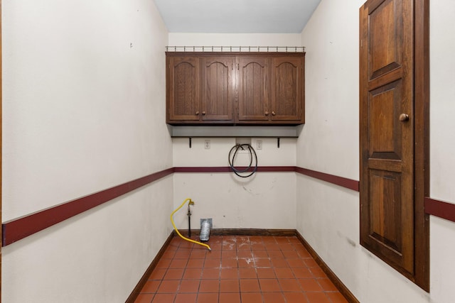 4113 Eaton Dr, Rockford, IL 61114 - laundry room featuring cabinet space and dark tile patterned flooring