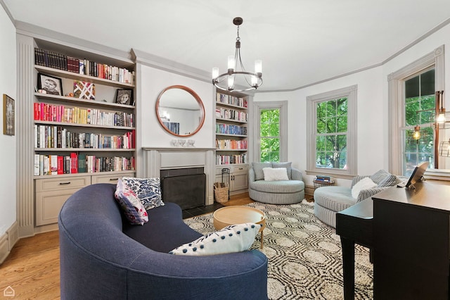 5729 S Harper Ave, Chicago, IL 60637 - living area featuring a fireplace with flush hearth, light wood-style floors, a chandelier, built in features, and ornamental molding