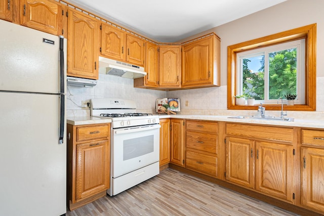 5401 S Nagle Ave, Chicago, IL 60638 - kitchen with white appliances, under cabinet range hood, decorative backsplash, light countertops, and light wood-style flooring