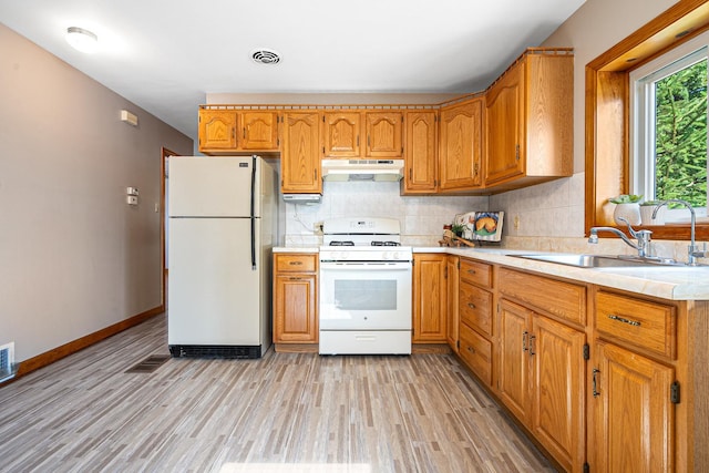 5401 S Nagle Ave, Chicago, IL 60638 - kitchen with white appliances, under cabinet range hood, light countertops, light wood-style flooring, and backsplash