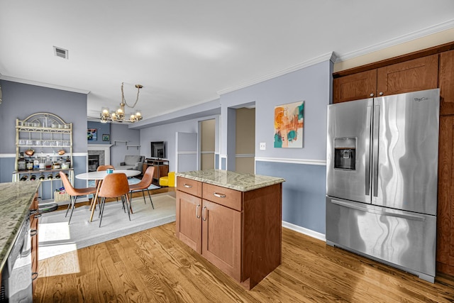 26711 S Greenbriar Dr, Monee, IL 60449 - kitchen with stainless steel fridge, light wood-style floors, a chandelier, light stone countertops, and ornamental molding