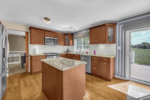 26711 S Greenbriar Dr, Monee, IL 60449 - kitchen with stainless steel appliances, light wood finished floors, a center island, and light stone countertops