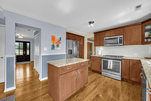 26711 S Greenbriar Dr, Monee, IL 60449 - kitchen featuring appliances with stainless steel finishes, light wood-type flooring, backsplash, glass insert cabinets, and crown molding