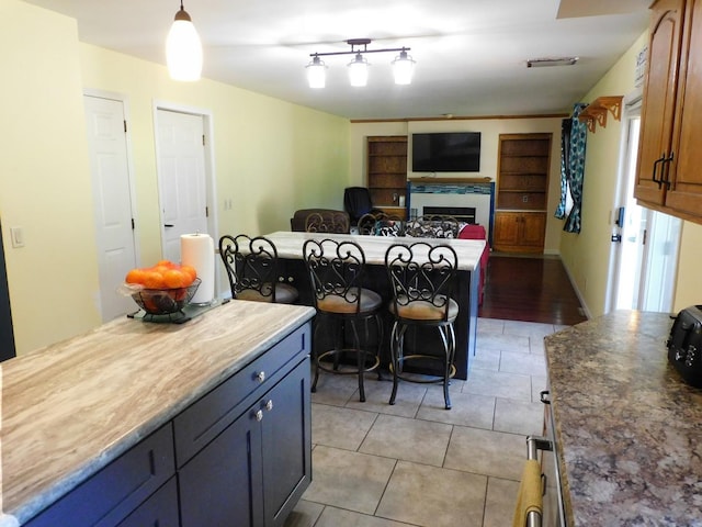 565 Sandra Cir, Freeport, IL 61032 - kitchen with light tile patterned floors, a fireplace, open floor plan, and hanging light fixtures