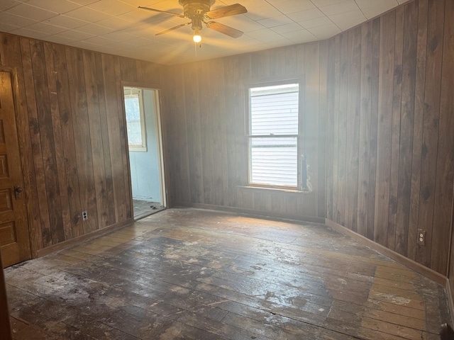 614 N Jackson St, Clinton, IL 61727 - unfurnished room featuring hardwood / wood-style flooring, ceiling fan, and wood walls