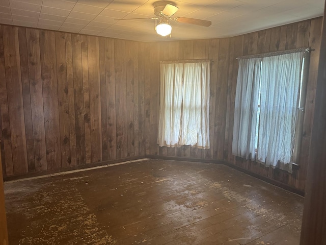 614 N Jackson St, Clinton, IL 61727 - unfurnished room featuring hardwood / wood-style floors, ceiling fan, and wood walls