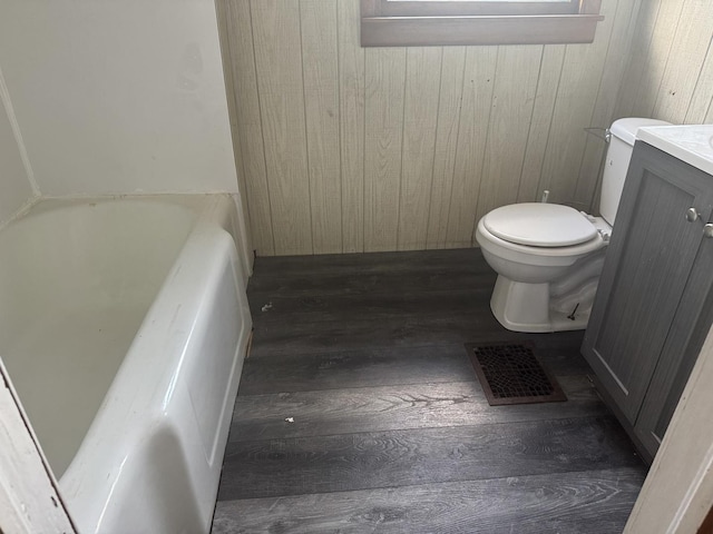 614 N Jackson St, Clinton, IL 61727 - bathroom featuring wood finished floors, a tub, wood walls, and vanity
