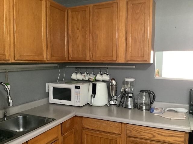 427 Kenyon Ave, Romeoville, IL 60446 - kitchen featuring white microwave, light countertops, and brown cabinets