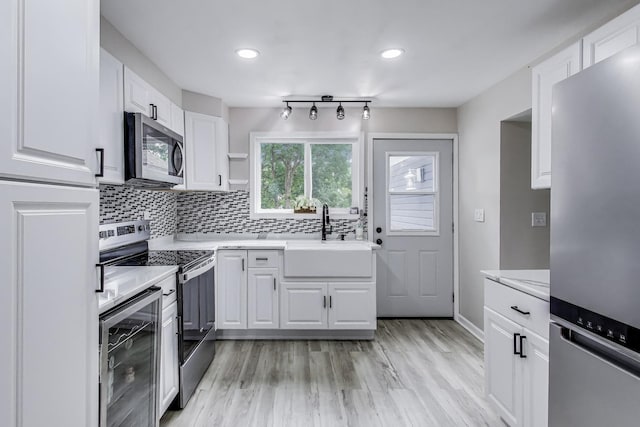 43173 N Lake Ave, Antioch, IL 60002 - kitchen featuring stainless steel appliances, wine cooler, white cabinetry, light countertops, and backsplash