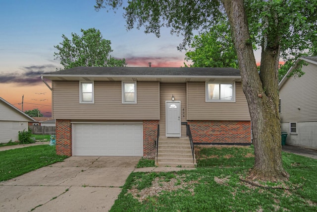 609 W Romeo Rd, Romeoville, IL 60446 - raised ranch featuring brick siding, concrete driveway, a garage, and a lawn
