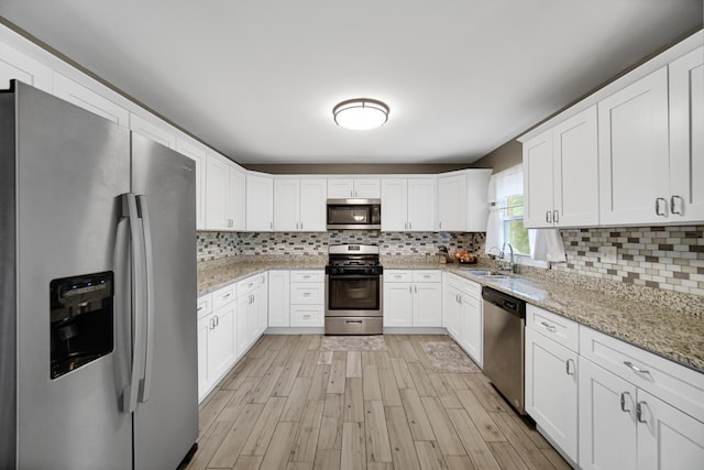 609 W Romeo Rd, Romeoville, IL 60446 - kitchen featuring appliances with stainless steel finishes, backsplash, light wood-type flooring, and white cabinetry