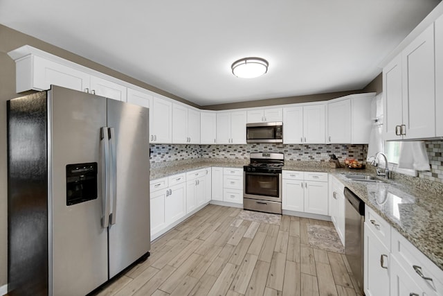 609 W Romeo Rd, Romeoville, IL 60446 - kitchen featuring stainless steel appliances, light wood-style flooring, tasteful backsplash, and white cabinetry