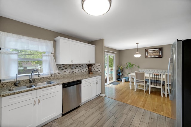 609 W Romeo Rd, Romeoville, IL 60446 - kitchen featuring appliances with stainless steel finishes, light wood finished floors, white cabinets, decorative backsplash, and light stone counters