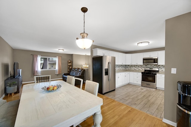 609 W Romeo Rd, Romeoville, IL 60446 - dining area featuring light wood-style floors and baseboards