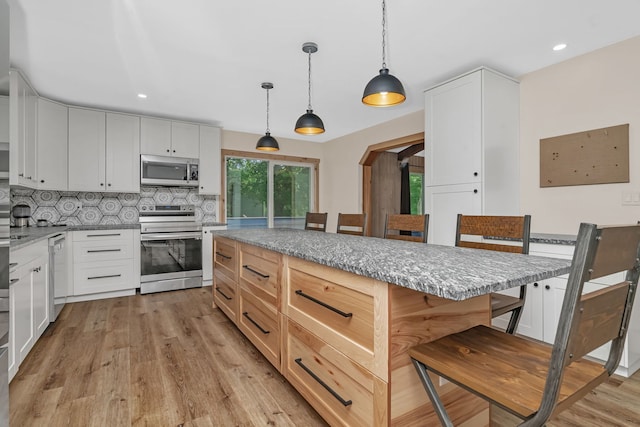 746 Old Stage Rd, Morris, IL 60450 - kitchen with stainless steel appliances, a breakfast bar, light stone countertops, light wood finished floors, and decorative backsplash