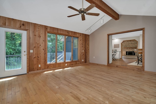 746 Old Stage Rd, Morris, IL 60450 - empty room featuring light wood finished floors, ceiling fan, plenty of natural light, wooden walls, and a fireplace