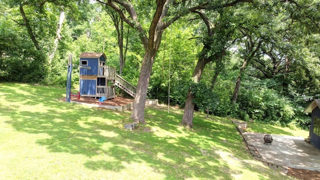746 Old Stage Rd, Morris, IL 60450 - view of green lawn featuring a fire pit, a patio area, a forest view, stairway, and an outbuilding