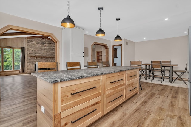 746 Old Stage Rd, Morris, IL 60450 - kitchen with dark countertops, light wood-style floors, a fireplace, light brown cabinetry, and pendant lighting