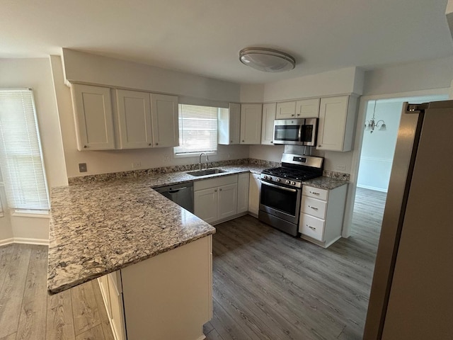 105 Golf View Cir, Prospect Heights, IL 60070 - kitchen featuring stainless steel appliances, a peninsula, light wood-style flooring, white cabinetry, and light stone countertops