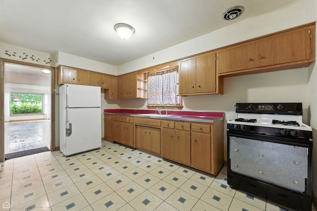 2644 W 94th St, Evergreen Park, IL 60805 - kitchen with freestanding refrigerator, gas range, and brown cabinets
