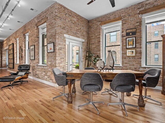 2035 W Charleston St Unit 205, Chicago, IL 60647 - dining area with brick wall, track lighting, wood finished floors, and ceiling fan