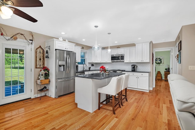 2831 E 28th Rd, Marseilles, IL 61341 - kitchen with stainless steel appliances, a kitchen bar, white cabinetry, light wood-style flooring, and recessed lighting
