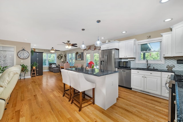 2831 E 28th Rd, Marseilles, IL 61341 - kitchen with stainless steel appliances, open floor plan, a kitchen bar, white cabinetry, and recessed lighting
