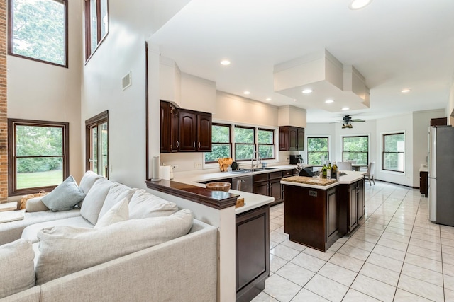 2809 Jenny Jae Ln, Crystal Lake, IL 60012 - kitchen with stainless steel appliances, open floor plan, dark brown cabinets, light tile patterned floors, and light countertops