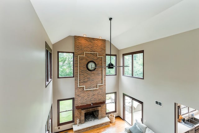 2809 Jenny Jae Ln, Crystal Lake, IL 60012 - living area featuring high vaulted ceiling, a fireplace, light wood-type flooring, and healthy amount of natural light