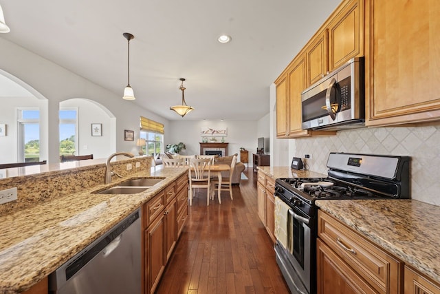 501 Blackstone Ct, Lake Villa, IL 60046 - kitchen with appliances with stainless steel finishes, light stone counters, decorative backsplash, dark wood-type flooring, and a fireplace