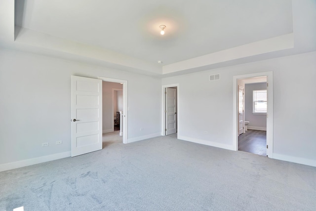 24465 S St Peters Dr, Channahon, IL 60410 - unfurnished bedroom featuring a tray ceiling, carpet floors, and connected bathroom