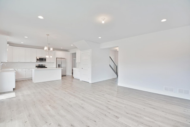 24465 S St Peters Dr, Channahon, IL 60410 - unfurnished living room with light wood finished floors, a chandelier, recessed lighting, and stairway