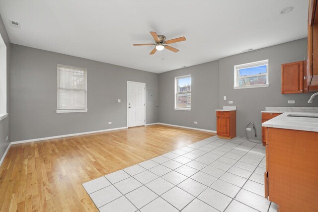 6139 S King Dr, Chicago, IL 60637 - kitchen featuring ceiling fan, light wood-type flooring, light countertops, brown cabinets, and open floor plan