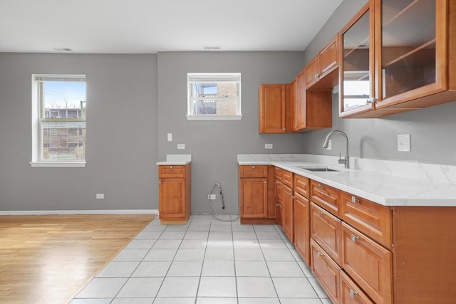 6139 S King Dr, Chicago, IL 60637 - kitchen featuring brown cabinetry, glass insert cabinets, and light wood-type flooring