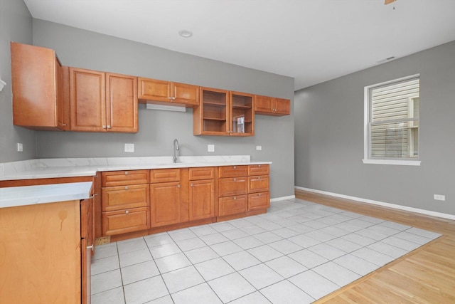 6139 S King Dr, Chicago, IL 60637 - kitchen with light countertops, light wood finished floors, brown cabinets, and glass insert cabinets