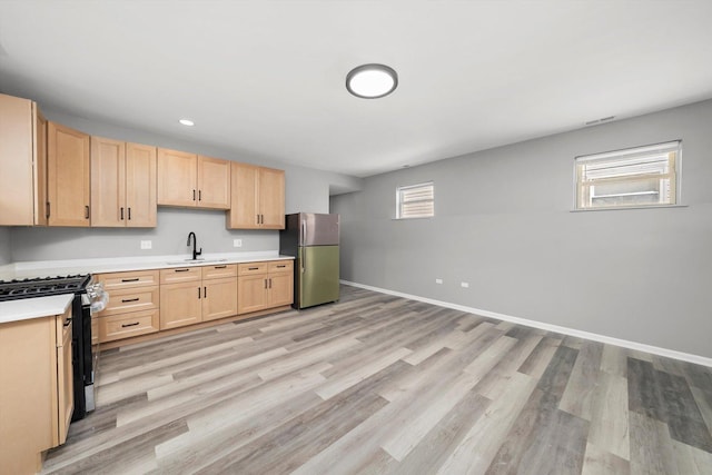 6139 S King Dr, Chicago, IL 60637 - kitchen featuring freestanding refrigerator, range with gas stovetop, light brown cabinetry, light countertops, and light wood-style floors
