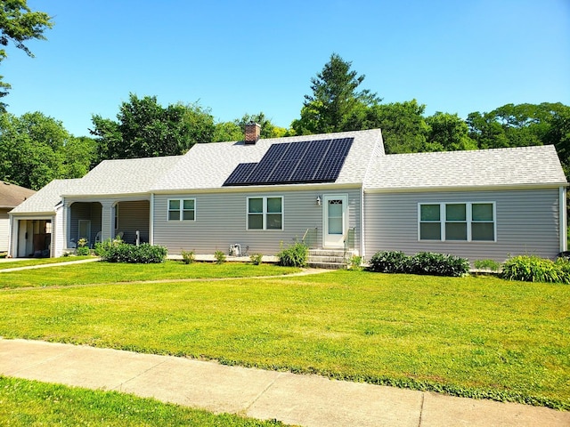 1080 E Bluff St, Marseilles, IL 61341 - ranch-style home with solar panels, a front lawn, a chimney, an attached garage, and roof with shingles