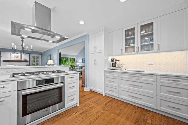 95 Warrington Dr, Lake Bluff, IL 60044 - kitchen with appliances with stainless steel finishes, wall chimney exhaust hood, a chandelier, white cabinetry, and recessed lighting