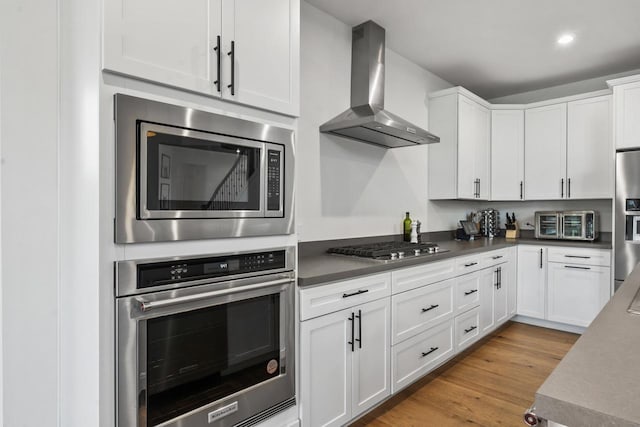 940 Treeline Dr, Algonquin, IL 60102 - kitchen featuring stainless steel appliances, wall chimney range hood, white cabinetry, light wood-style flooring, and recessed lighting