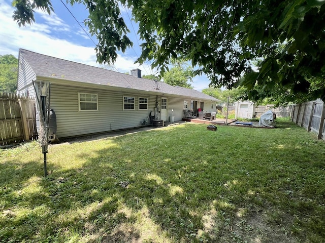 302 Kelly Ct, Champaign, IL 61821 - back of house featuring a storage unit, a fenced backyard, a patio area, and a chimney