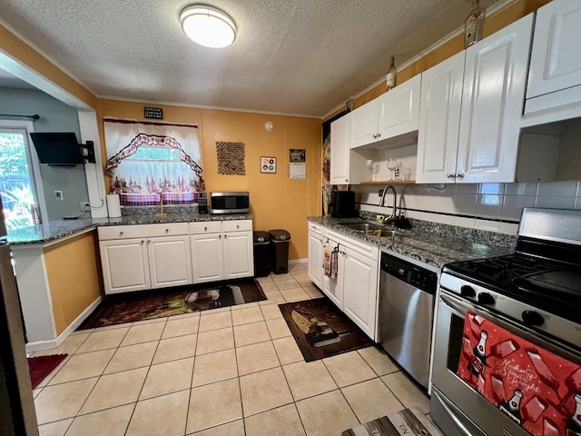 302 Kelly Ct, Champaign, IL 61821 - kitchen with stainless steel appliances, white cabinets, light tile patterned flooring, and dark stone counters